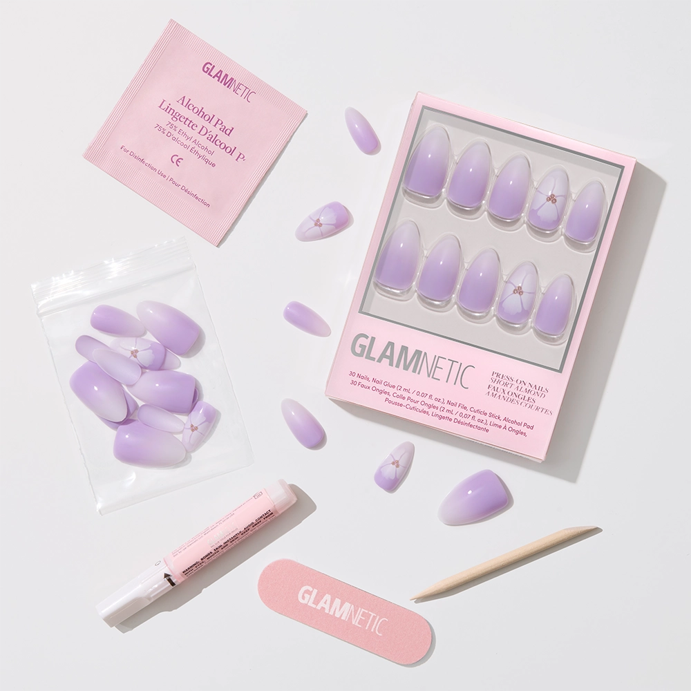 The glamnetic Lilac Reef Press-On Nail Set features pastel purple and pink lavender ombré almond nails with charming small accents. Includes extra nails, nail file, wooden cuticle stick, alcohol pad, and nail glue. - Product image
