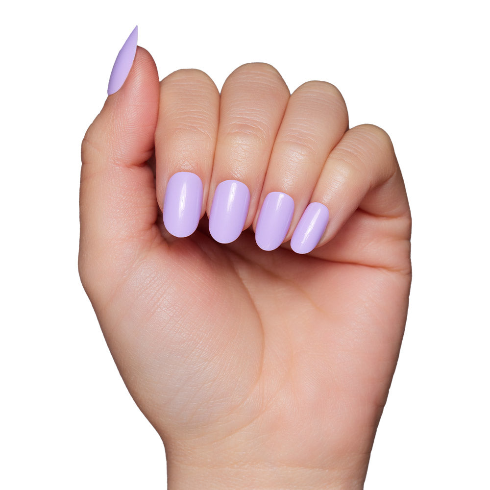 A hand with neatly manicured nails, featuring the glossy light lavender Lilac nail set by glamnetic, is displayed against a white background. - Product image