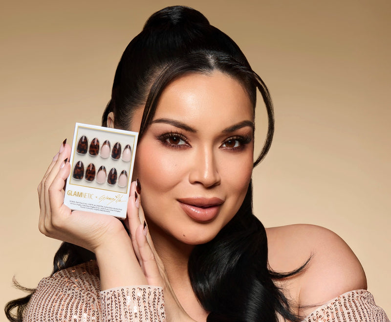 Woman holding a glamnetic glamzilla collection against a beige background