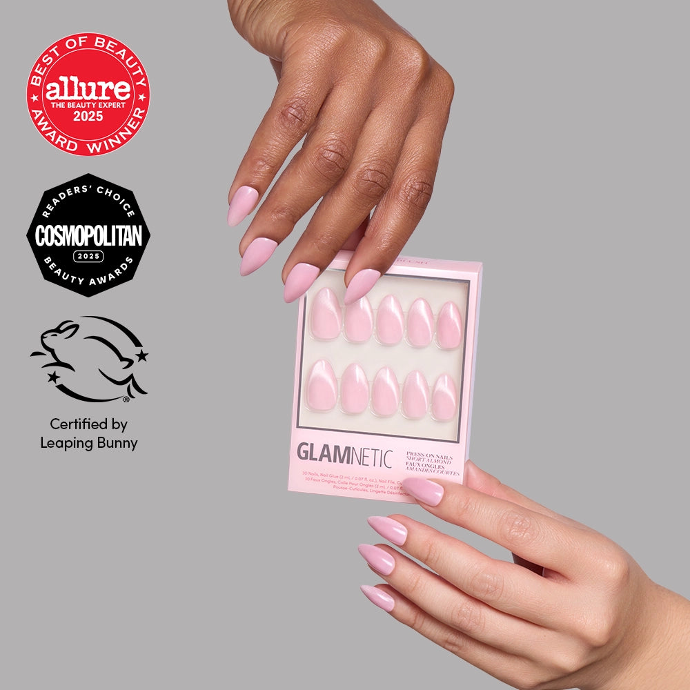 A hand holding a box of Glamnetic Lovers Blush short almond velvet-finish press-on nails, featuring Allure Best of Beauty, Cosmopolitan Readers Choice, and Leaping Bunny certification logos.