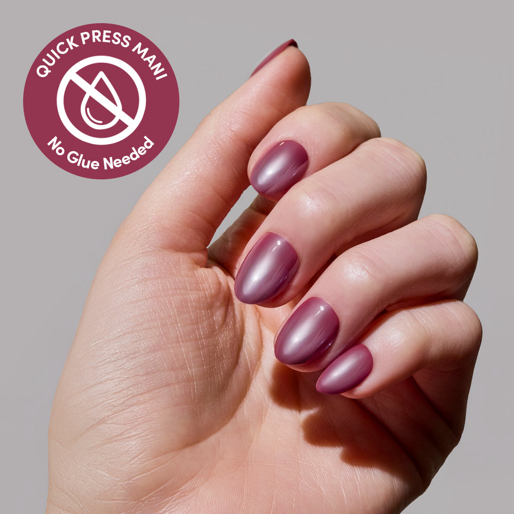 A hand with glossy, mauve glamnetic Mauve Muse press-on nails is shown. A circular label reads Quick Press Mani, No Glue Needed with a crossed-out glue bottle, highlighting these easy-to-apply no-glue nails. - Product image