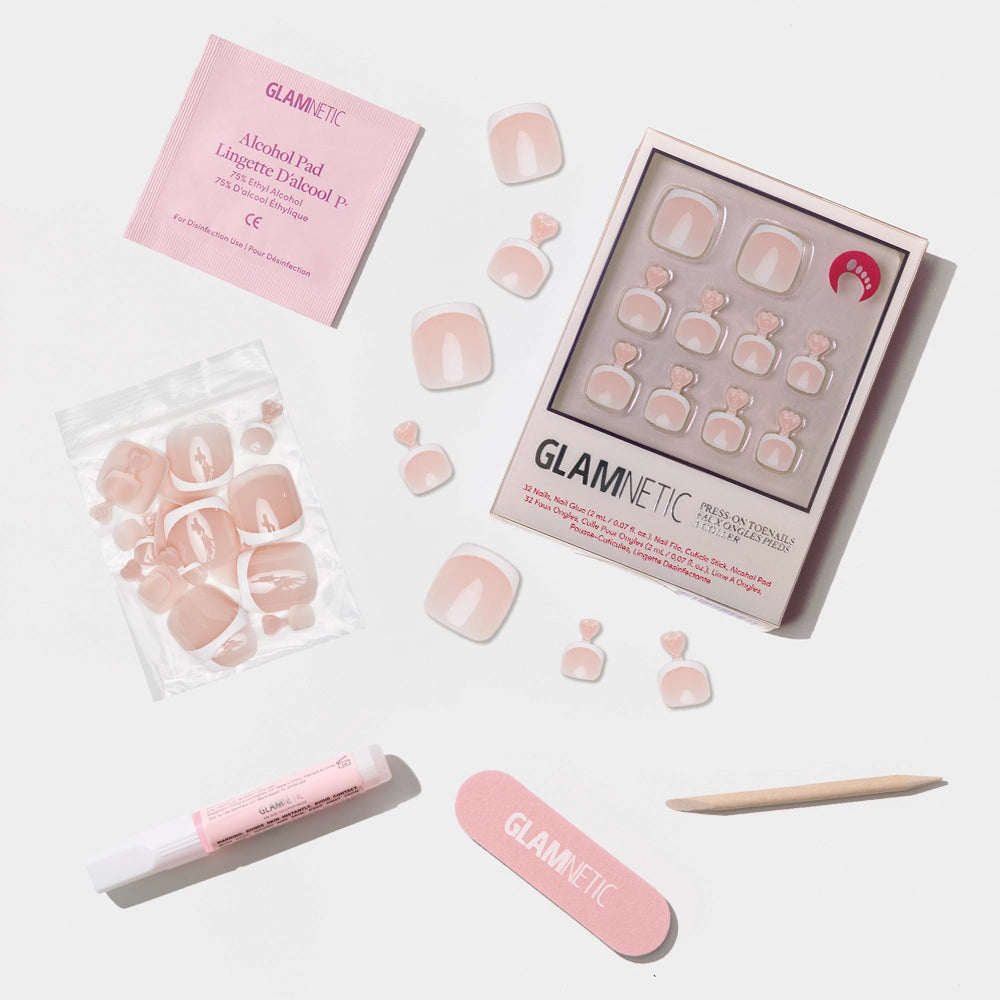 A flat-lay of the Glamnetic soft nude pink press-on toenail kit featuring a glossy solid color and full prep set. - Product image