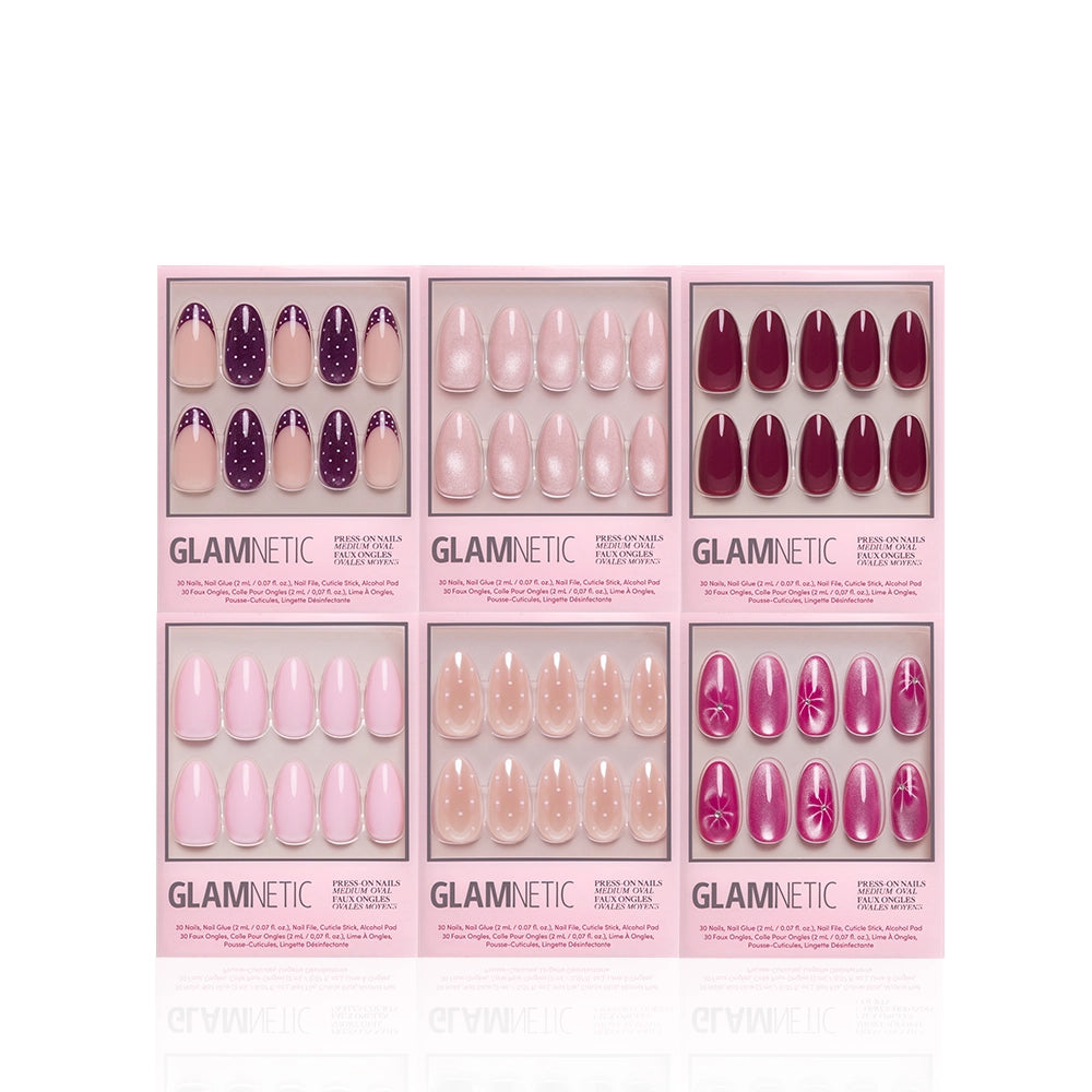 Six boxes of glamnetic Medium Oval Wardrobe salon-quality press-on nails are arranged in two rows, showcasing a variety of shades including pink, nude, purple, and maroon with finishes like glitter, glossy, and floral designs—all housed in chic pink packaging. These medium oval press-on nails from glamnetic offer both style and durability for a long-lasting manicure. - Product image