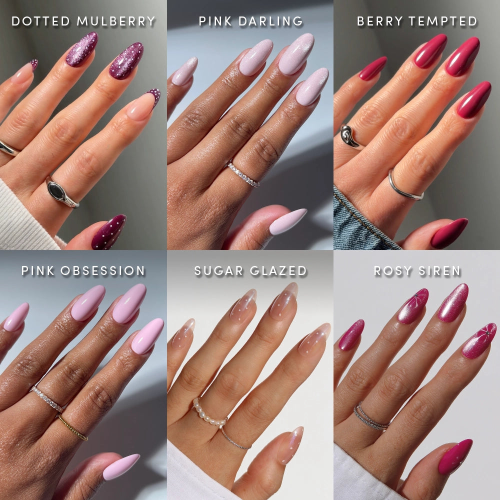 Six hands display different nail designs from glamnetic’s Medium Oval Wardrobe—Dotted Mulberry, Pink Darling, Berry Tempted, Pink Obsession, Sugar Glazed, and Rosy Siren. Each set features a unique combination of pink and red hues with distinct finishes and accents. These salon-quality press-on nails offer a medium oval shape for a flawless, trendy look that’s long-lasting. - Product image