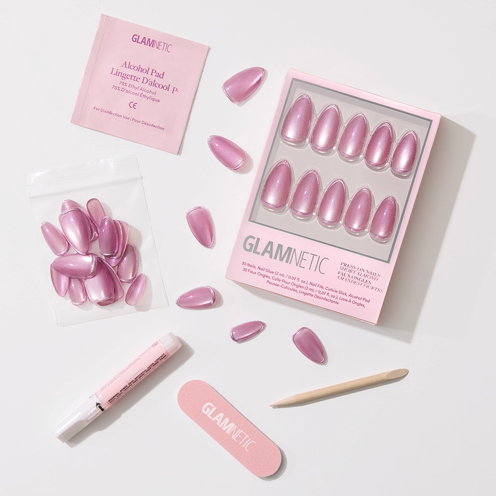 Introducing Mertini by glamnetic: a pink, iridescent press-on nail set with velvet finish and foil accents. Comes with alcohol pad, nail glue, file, cuticle stick, extra nails—all arranged on a light background. - Product image
