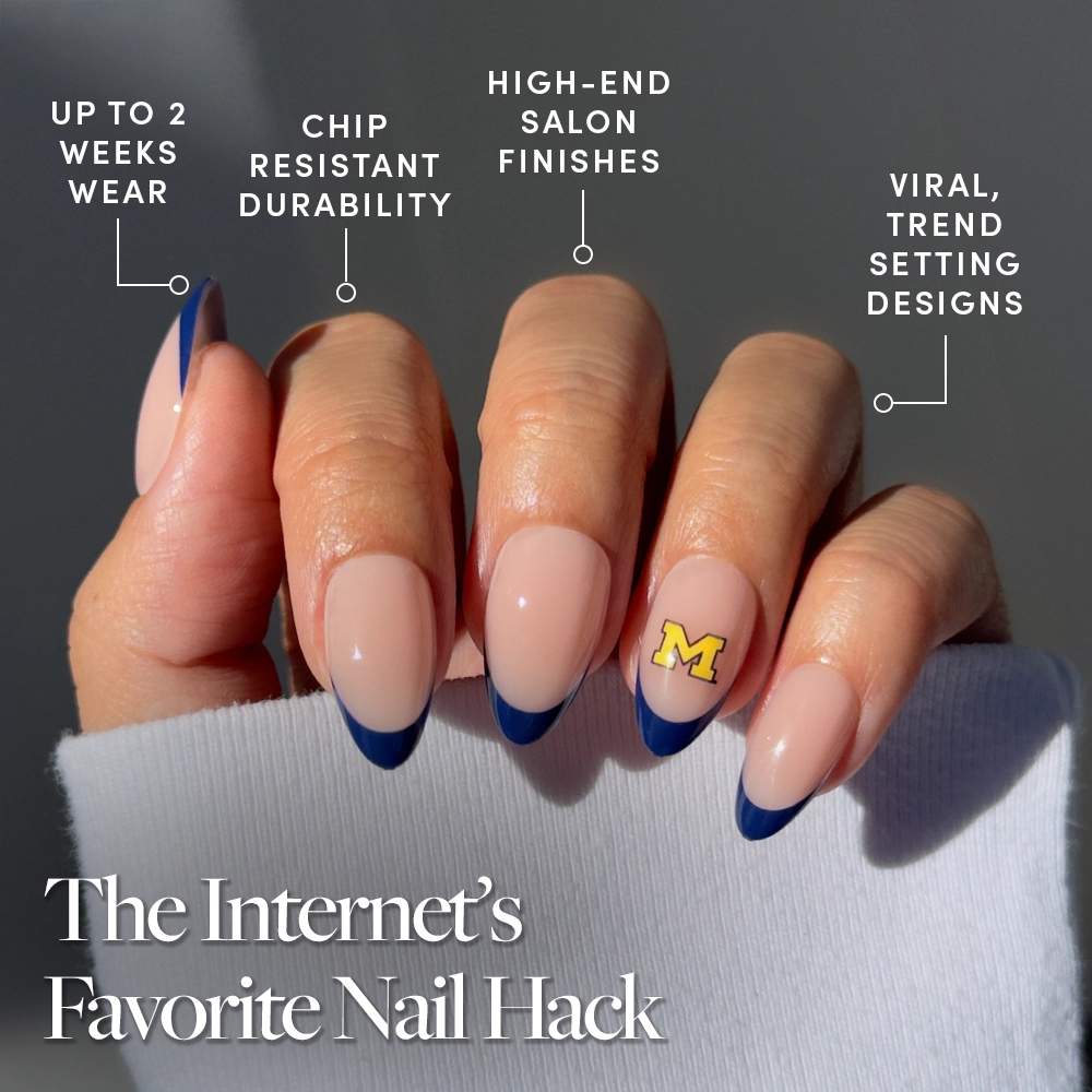 A hand with nude nails and blue French tips, plus a yellow M logo, wears the glamnetic Michigan Wolverines Press-On Nail Set—offering salon-quality, chip-resistant nails for up to 2 weeks. Caption: The Internet’s Favorite Nail Hack. - Product image