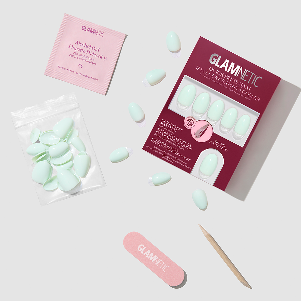 Glamnetic Minty Cloud extra short oval mint green press-on nails, a plastic bag of additional nail tips, an alcohol prep pad, a nail file, and a cuticle stick. - Product image