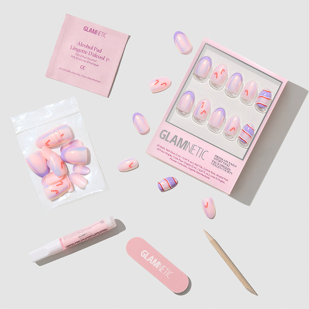 A set of glamnetic Miss Minty Press-On Nails in a chic short almond shape—featuring pink and purple hues—along with glue, a nail file, wooden stick, alcohol pad, and extra nails are arranged neatly on a light gray background, making them perfect for your next holiday manicure. - Product image