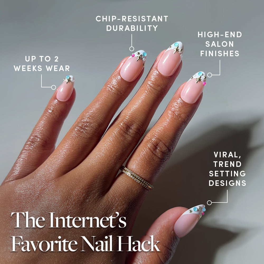 A hand with pink, decorated nails is shown, labeled with benefits like “up to 2 weeks wear,” “chip-resistant durability,” “high-end salon finishes,” and “viral, trend-setting designs.” Featuring Moonstone French tip press-on nails by glamnetic for a flawless jewel-encrusted mani. Text: “The Internet’s Favorite Nail Hack.”. - Product image