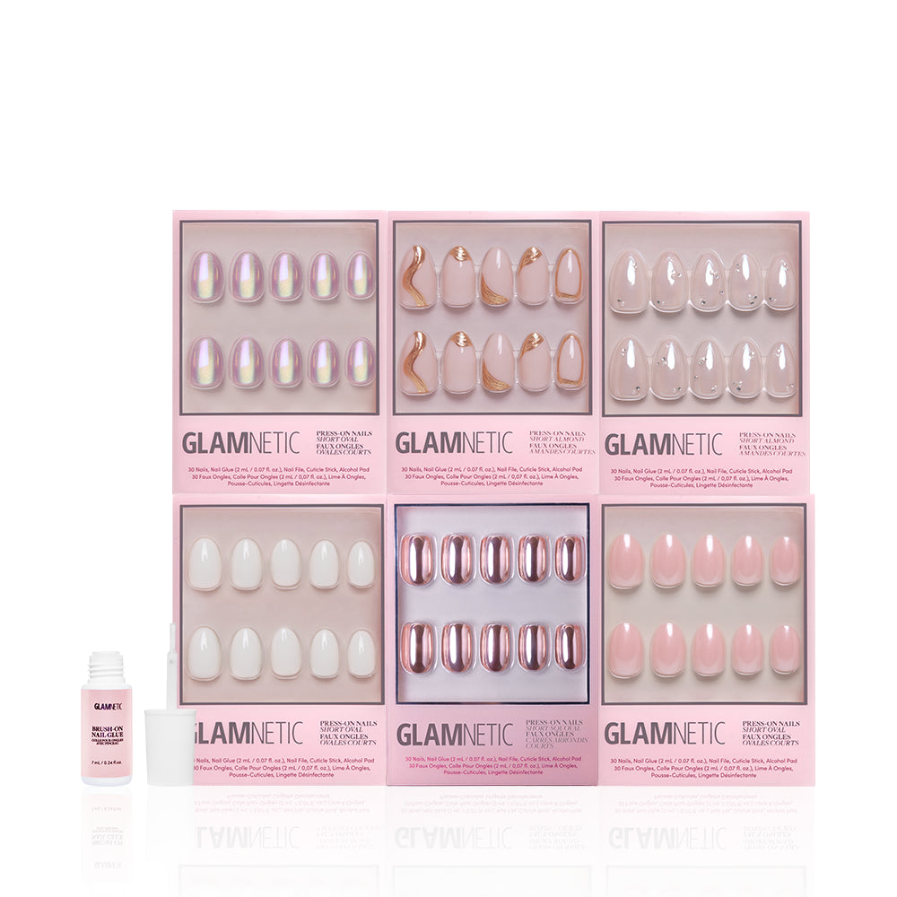 The glamnetic NYE Rendezvous Bundle features six sets of short press-on nails in pink, nude, and iridescent styles, including a soft glam look, arranged in two rows with a small nail glue bottle placed to the left. - Product image