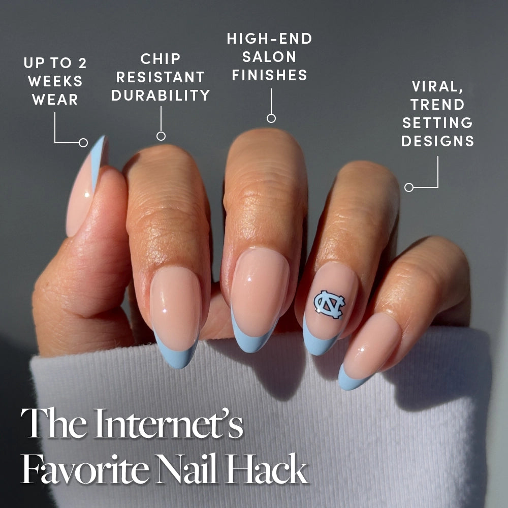 The North Carolina Tar Heels Press-On Nail Set by glamnetic features long, almond-shaped salon-quality nails with a nude base, Carolina-blue French tips, and a UNC logo. Enjoy trendy designs, a high-end finish, durability, and up to 2 weeks of wear. - Product image