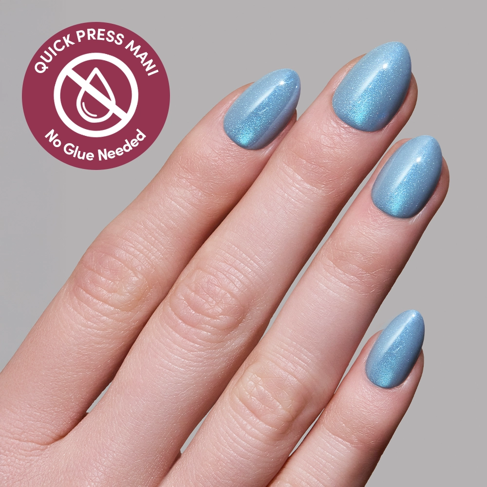A hand with neatly manicured nails painted in glamnetic’s Ocean Prism—a shimmery light blue—appears beside a badge that reads Quick Press Mani, No Glue Needed, featuring a droplet and crossed-out line icon for effortless press-ons. - Product image