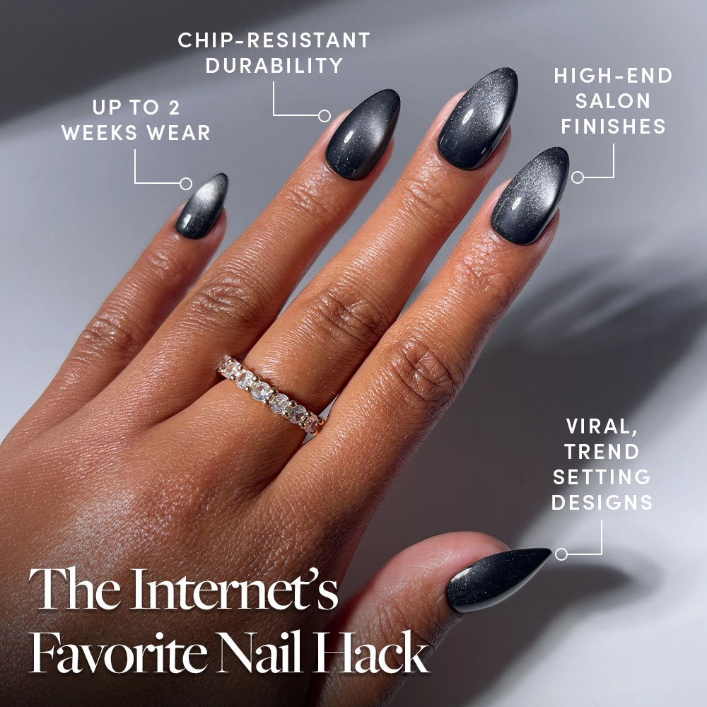 A hand with long, almond-shaped black ombre Obsidian press-on nails by glamnetic is shown. Text highlights features: up to 2 weeks of wear, chip-resistant durability, salon-quality press-ons with high-end finishes and trendsetting designs. A gold ring set with diamonds adorns one finger. - Product image