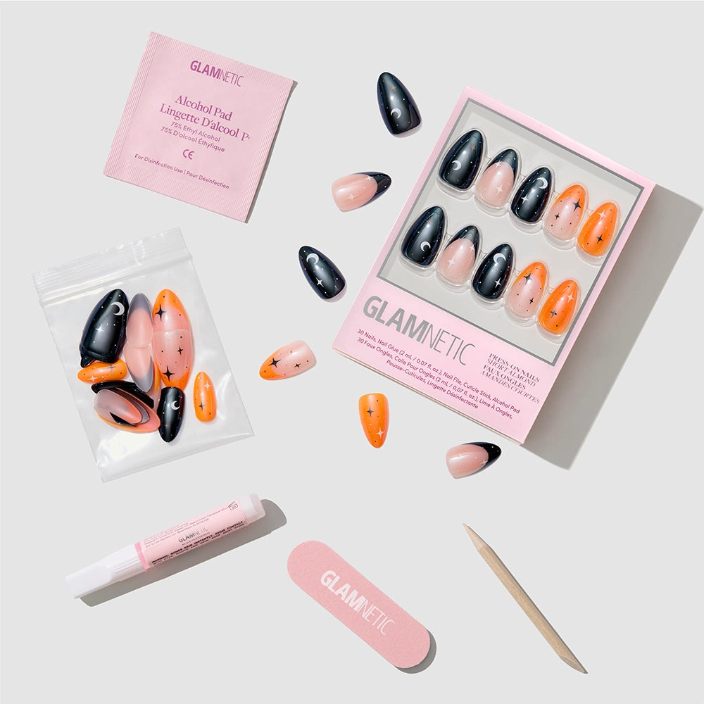 A set of glamnetic October Nights press-on nails in black, orange, and nude with glazed French tips is displayed on a white background, accompanied by an alcohol pad, nail glue, file, cuticle stick, and extra nails. - Product image