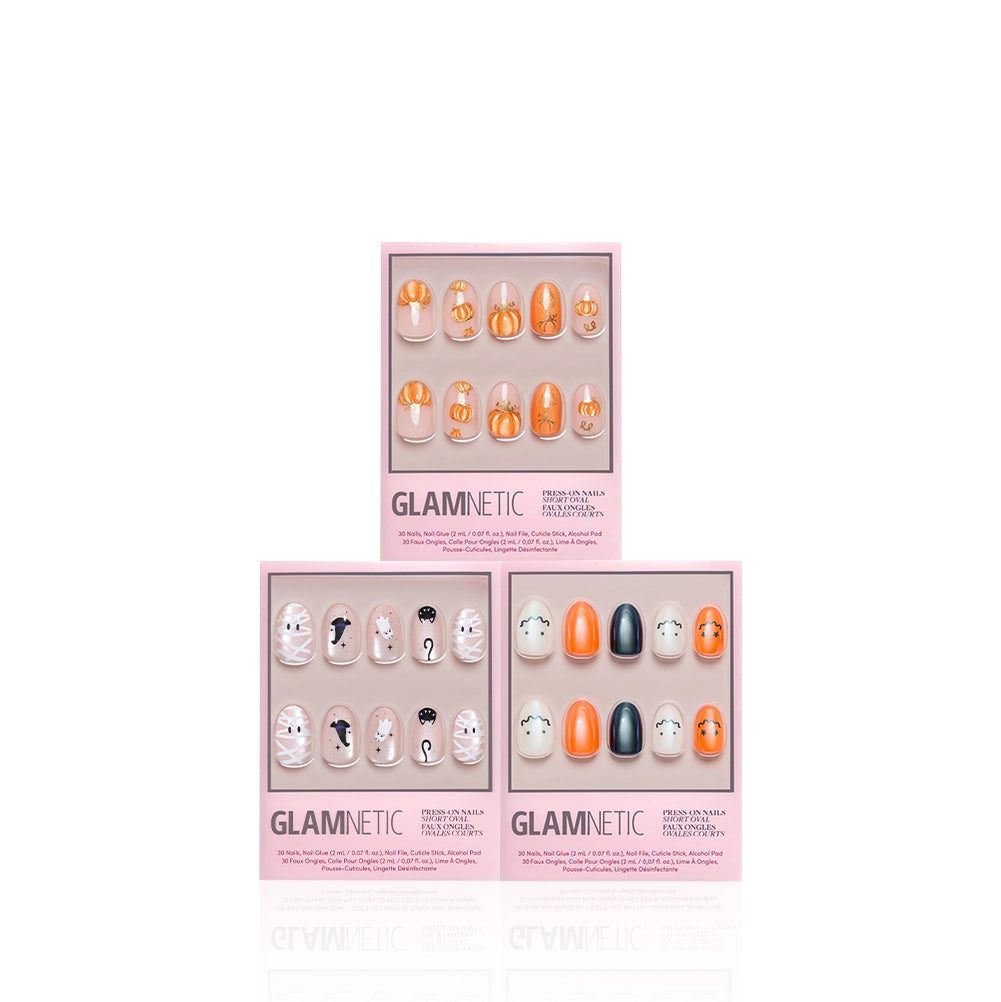 Three sets of glamnetic October Ovals press-on nails in pink packaging, each showcasing unique Halloween-inspired designs in orange, white, and black, are arranged on a white background. - Product image