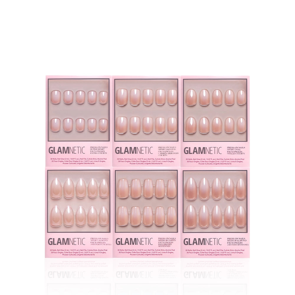 Six boxes from the glamnetic Ombré Obsession Bundle, featuring press-on nails in nude and pink ombré shades, are arranged in two rows of three. Each light pink box has a clear window displaying various shapes and sizes. - Product image