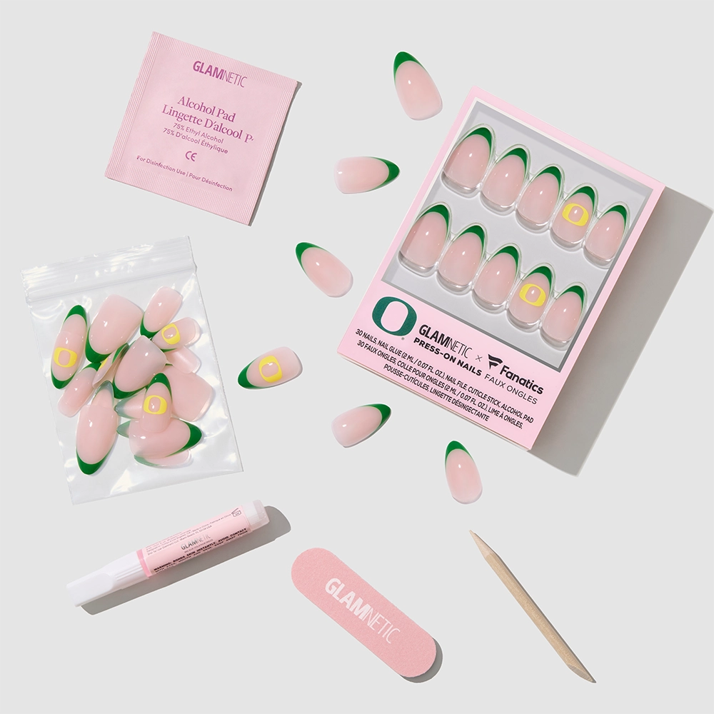 The glamnetic Oregon Ducks Press-On Nail Set features pink and green nails with nail glue, wooden stick, nail file, alcohol pad, and extra nails, all arranged on a light gray background. - Product image