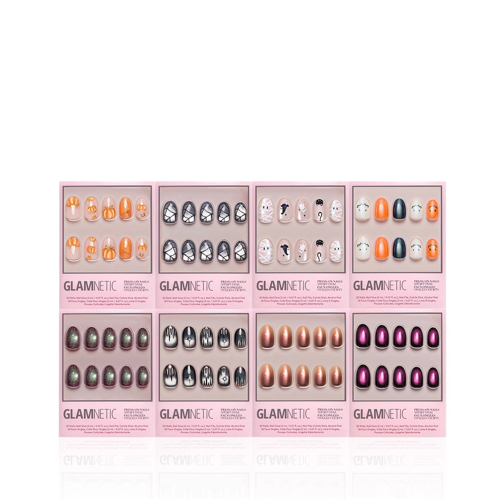Eight sets of Glamnetic Oval Occult press-on nail sets featuring short oval nails in various Halloween-themed designs and colors, all packaged in pink boxes with clear windows that showcase the different salon-quality styles. - Product image