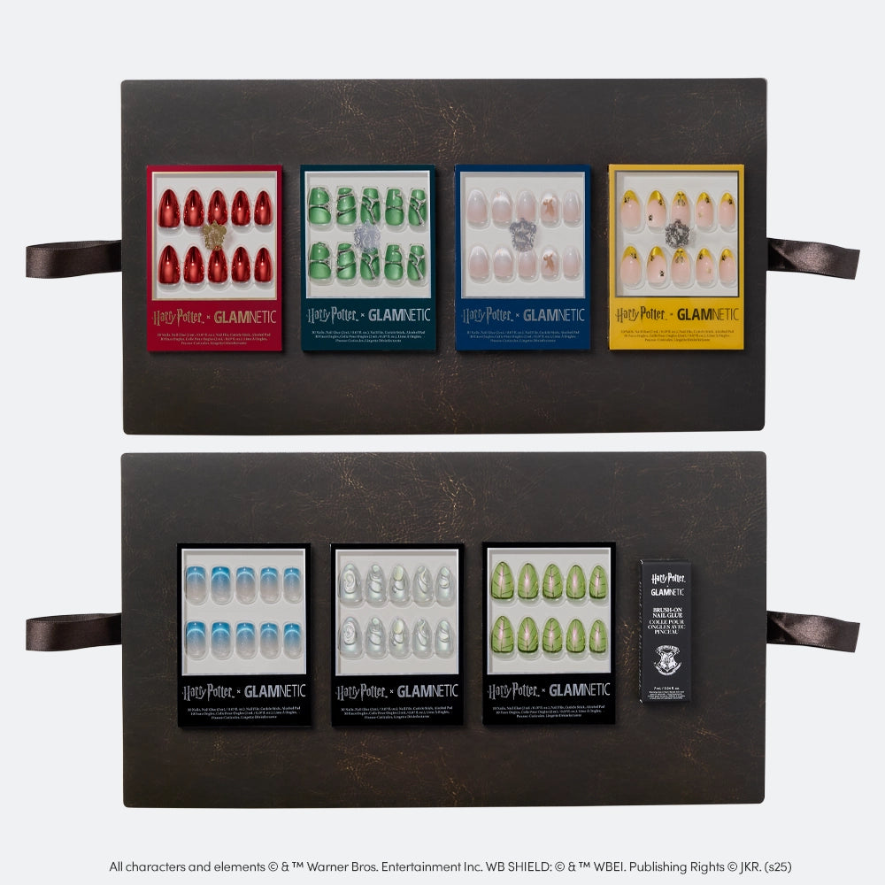 The Harry Potter™ x Glamnetic PR Box by glamnetic features eight collector’s sets of press-on nails, each with house-inspired designs in different colors, arranged in two rows on a dark tray with ribbon handles. - Product image