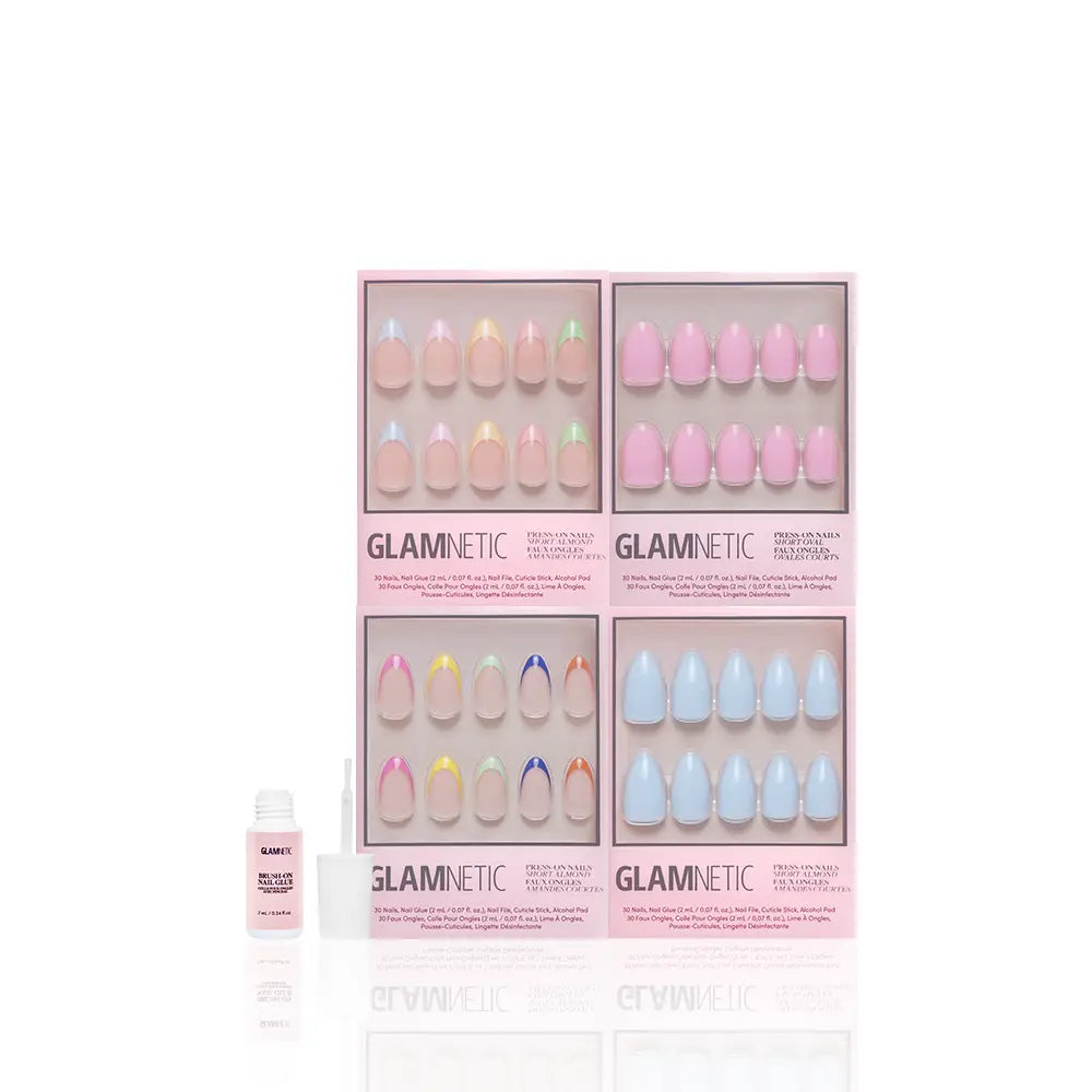 Four sets of Pastel Princess press-on nails by glamnetic are displayed in pink boxes, each showcasing trendy short almond shapes for a chic, salon-quality look at home. A small white bottle is placed in front of the nail sets on a white background. - Product image