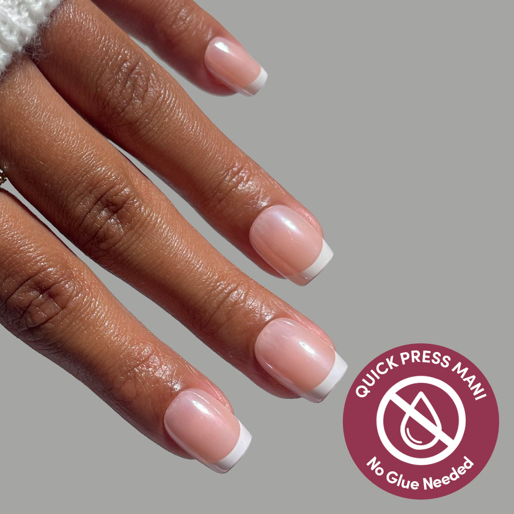 Hand with short, square-shaped Pearl Du Jour press-on nails featuring a classic French manicure design, with a badge reading Quick Press Mani, No Glue Needed. - Product image