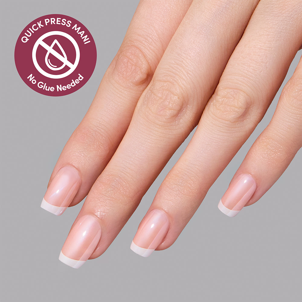 A hand wearing Pearl Du Jour glossy French tips as part of a salon-quality manicure, featuring a circular badge that reads Quick Press Mani, No Glue Needed. - Product image
