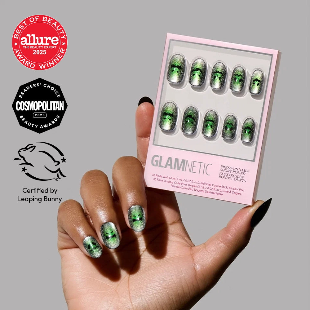 A hand holds a box of glamnetic Peek-o’-Lantern green ombre press-on nails with a velvet finish. Allure, Cosmopolitan, and Leaping Bunny beauty award badges are shown on the left.