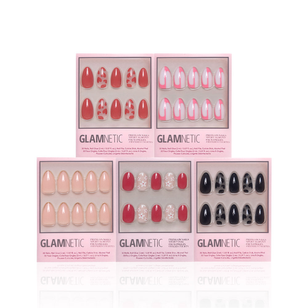 Five sets of glamnetic Perfect Match press-on nails come in pink boxes and include designs like solid red, red with leopard print, pink French tips, nude, nude with gems, and glossy black. These reusable nails are stylishly arranged in two rows.