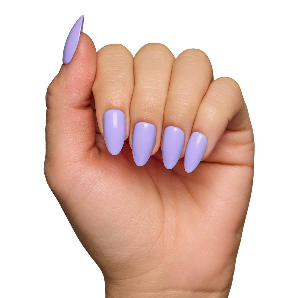 A hand with almond-shaped glamnetic Periwinkle press-on nails in a glossy finish, fingers curled inward, shown against a white background. - Product image