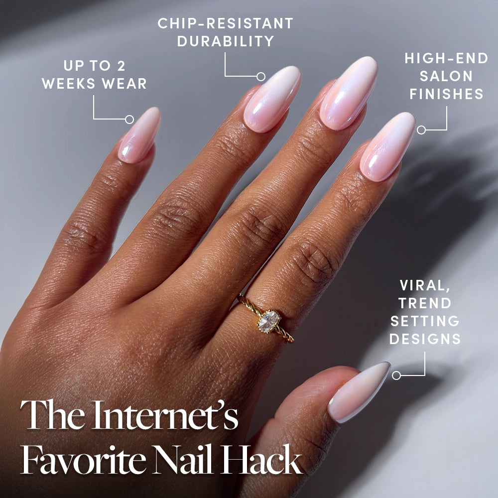 A hand with long, glossy, light pink "Pink Pearl" nails by glamnetic is shown. Text highlights features: up to 2 weeks wear, chip-resistant durability, high-end salon finishes, and viral, trend-setting designs. These ombre French tip salon-quality press-ons deliver a flawless look in minutes. A gold ring adorns the ring finger. - Product image