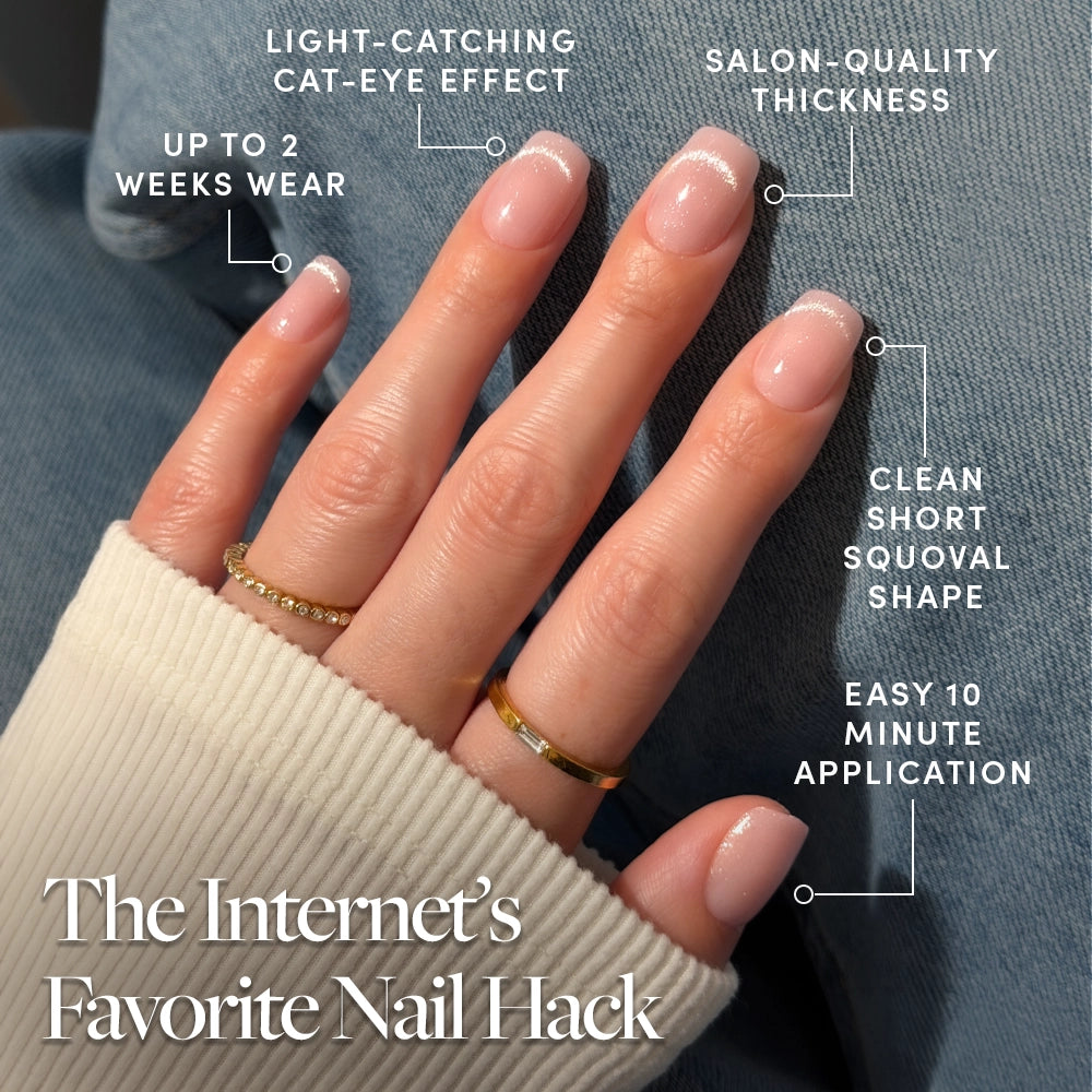 A hand with neatly manicured Pixie Dusted press-on nails by glamnetic, showcasing a subtle glittery French tip. Text highlights their cat-eye finish, salon-quality thickness, short squoval shape, up to 2 weeks of wear, and easy 10-minute application. - Product image