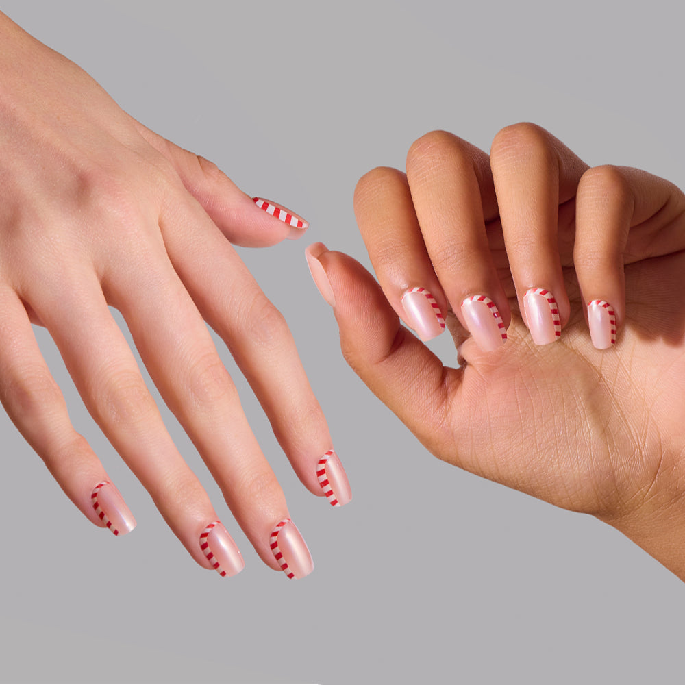 Pretty in Peppermint - Pretty in Peppermint glamnetic press-on nails featuring short, square-shaped tips with a clear, glazed base and red-and-white striped candy cane designs on two hands.