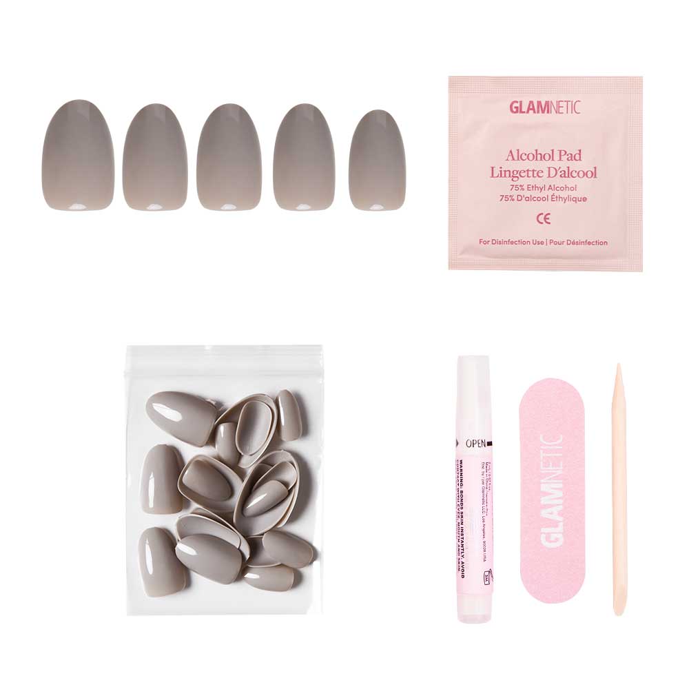 The glamnetic Pure Gray Nail Set includes taupe and gray glossy nails, an alcohol pad, extra nails in a resealable bag, nail glue, a pink file, and a wooden cuticle stick—all arranged on a white background. - Product image