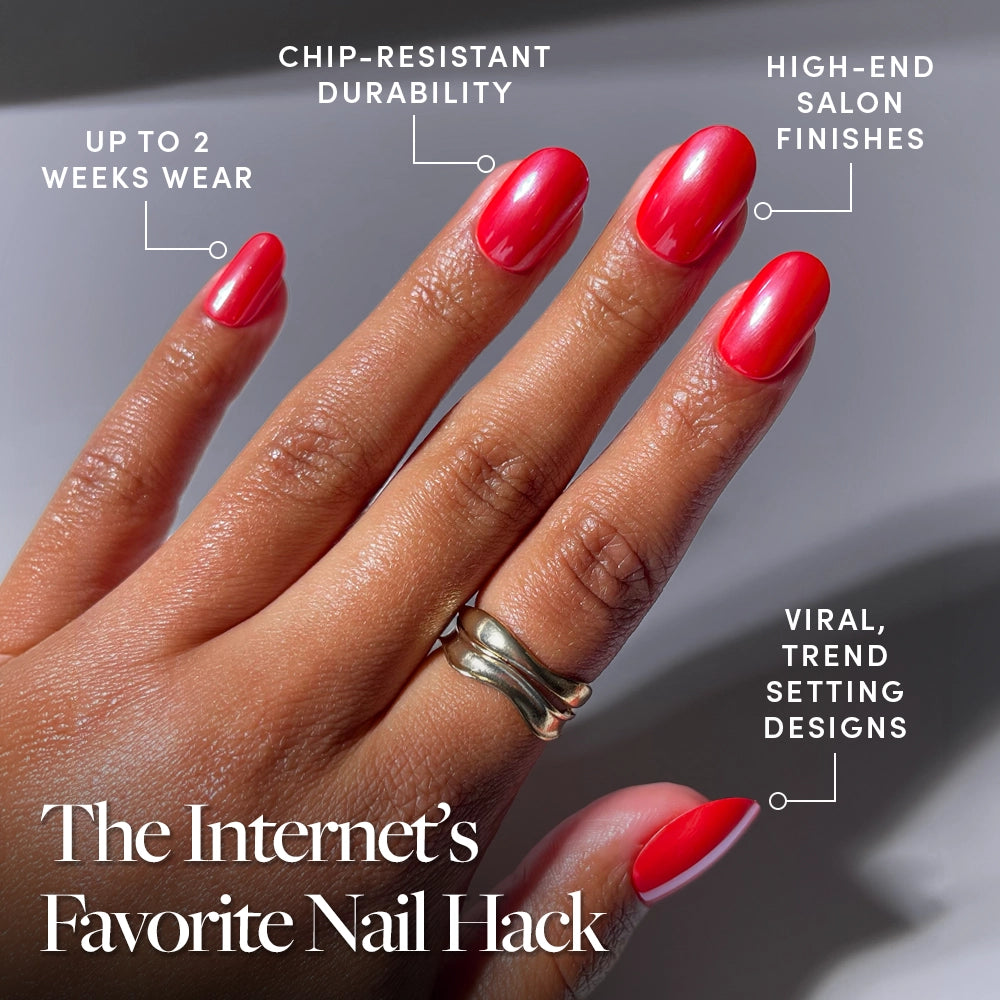 A hand wearing glamnetic's Red Confidence short round press-on nails is shown, featuring a bright red glossy finish. Benefits: up to 2 weeks wear, chip-resistant, salon-quality look, and trend-setting design. One finger has a gold ring. - Product image