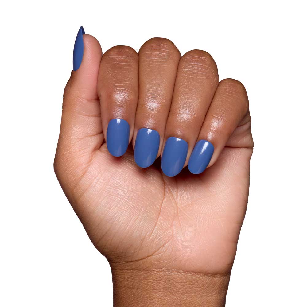 A hand with medium brown skin and neatly manicured nails painted in Regal Blue—a vegan, cruelty-free polish—shows off the glossy blue shade against a plain white background. - Product image