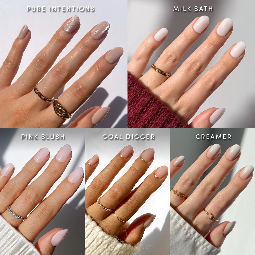 Five hands display different short, light nude manicures from glamnetic’s Clean Girl Round Up collection, labeled Pure Intentions, Milk Bath, Pink Blush, Goal Digger, and Creamer. Each hand shows off salon-quality nails in flattering short round shapes adorned with rings and photographed in soft natural light.