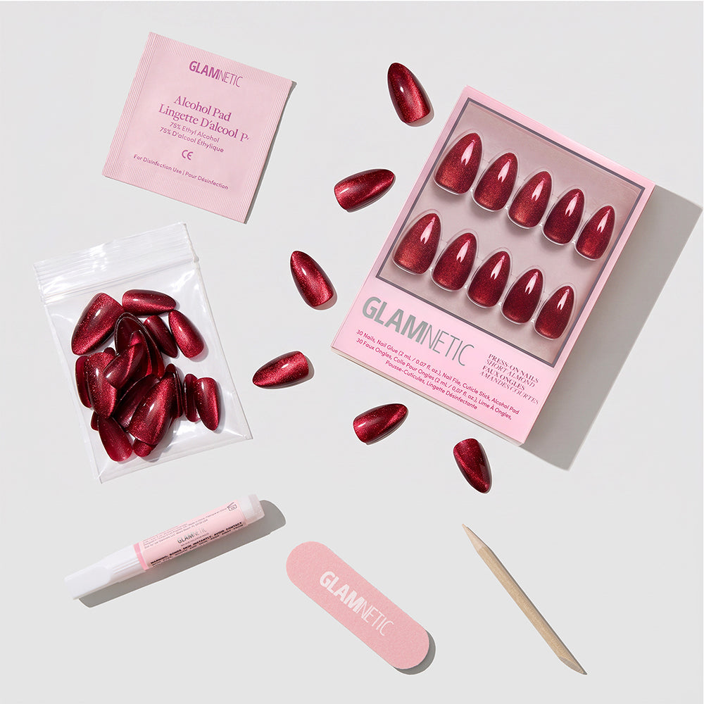 Ruby Slipper - Short almond Glamnetic Ruby Slipper press-on nails with a velvet finish, including a storage box, nail glue, an alcohol pad, a nail file, and a wooden cuticle pusher.