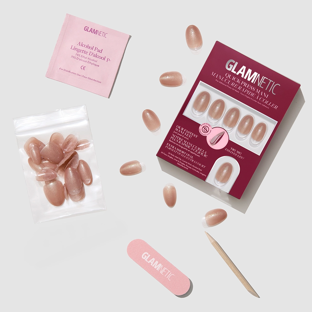 The glamnetic Sparkly Brown set includes quick press-on manis: a box of stick-on nails, nude-colored press-ons, nail file, wooden cuticle stick, glue, and an alcohol pad, all arranged on a light background. - Product image