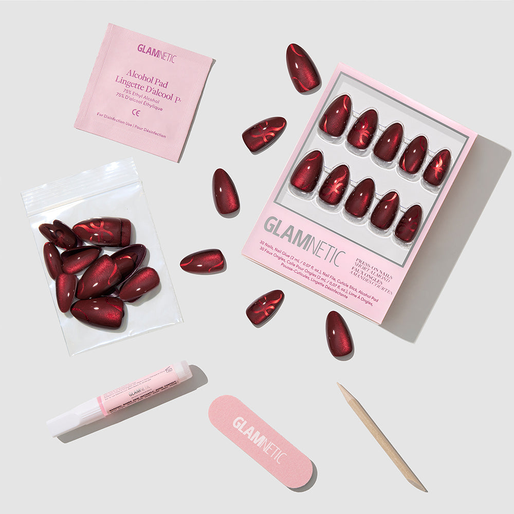 Scarlet Ribbons short almond nails in a deep red metallic velvet finish, including a storage box, nail glue, alcohol prep pad, nail file, and wooden cuticle stick. - Product image