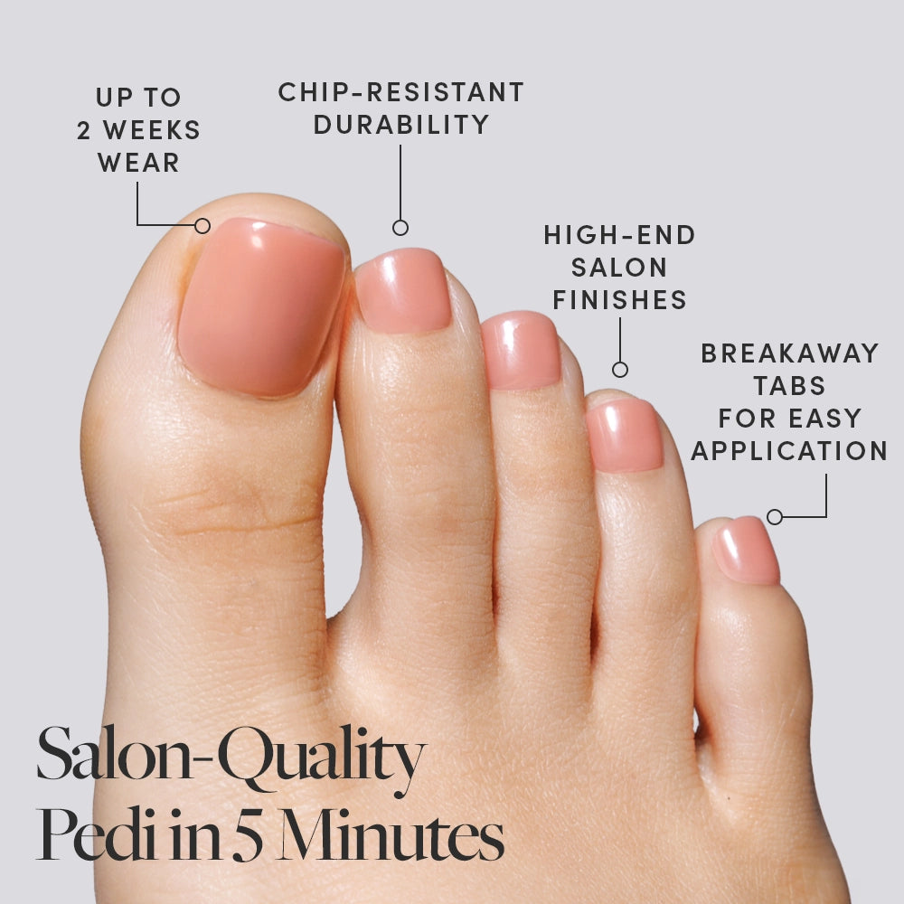 A close-up of a foot wearing peach Glamnetic press-on toenails, with callouts highlighting up to 2 weeks wear, chip-resistant durability, high-end finishes, and breakaway tabs. - Product image
