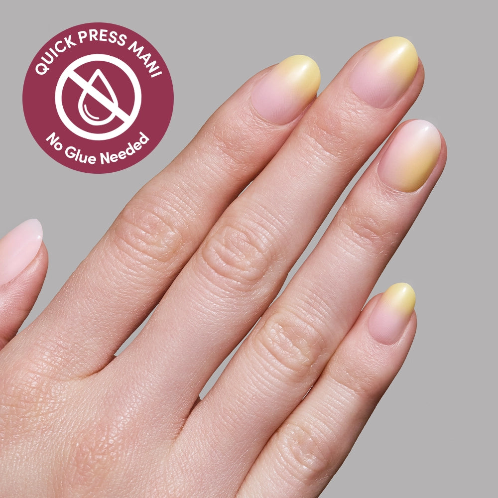 A hand with oval-shaped, yellow-to-pink ombre Sherbert press-on nails by glamnetic is shown against a gray background. A circular label says QUICK PRESS MANI, No Glue Needed with a droplet graphic to highlight the no-glue design. - Product image