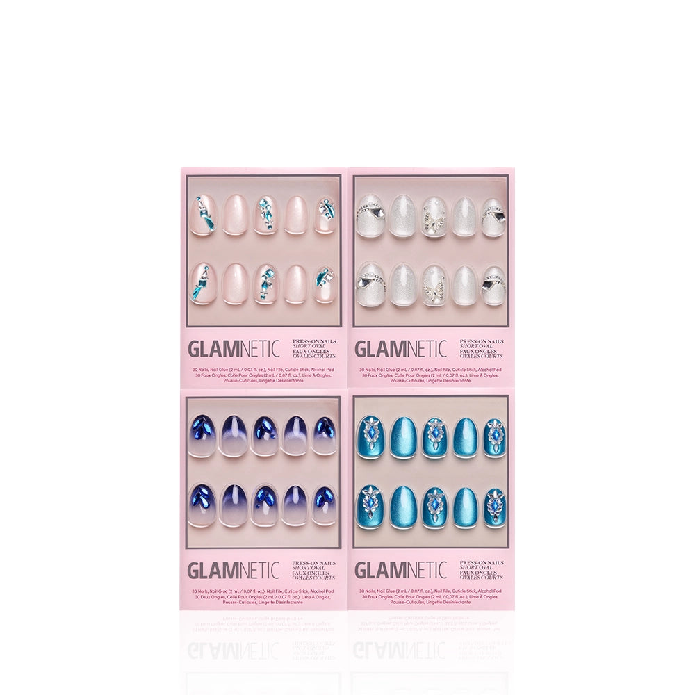 Four packs of glamnetic Short Oval Attraction press-on nails are arranged in a grid. Designs feature pink with blue flowers, white with silver accents, navy velvet shimmer, and teal with rhinestones. Each pack contains 12 nails.