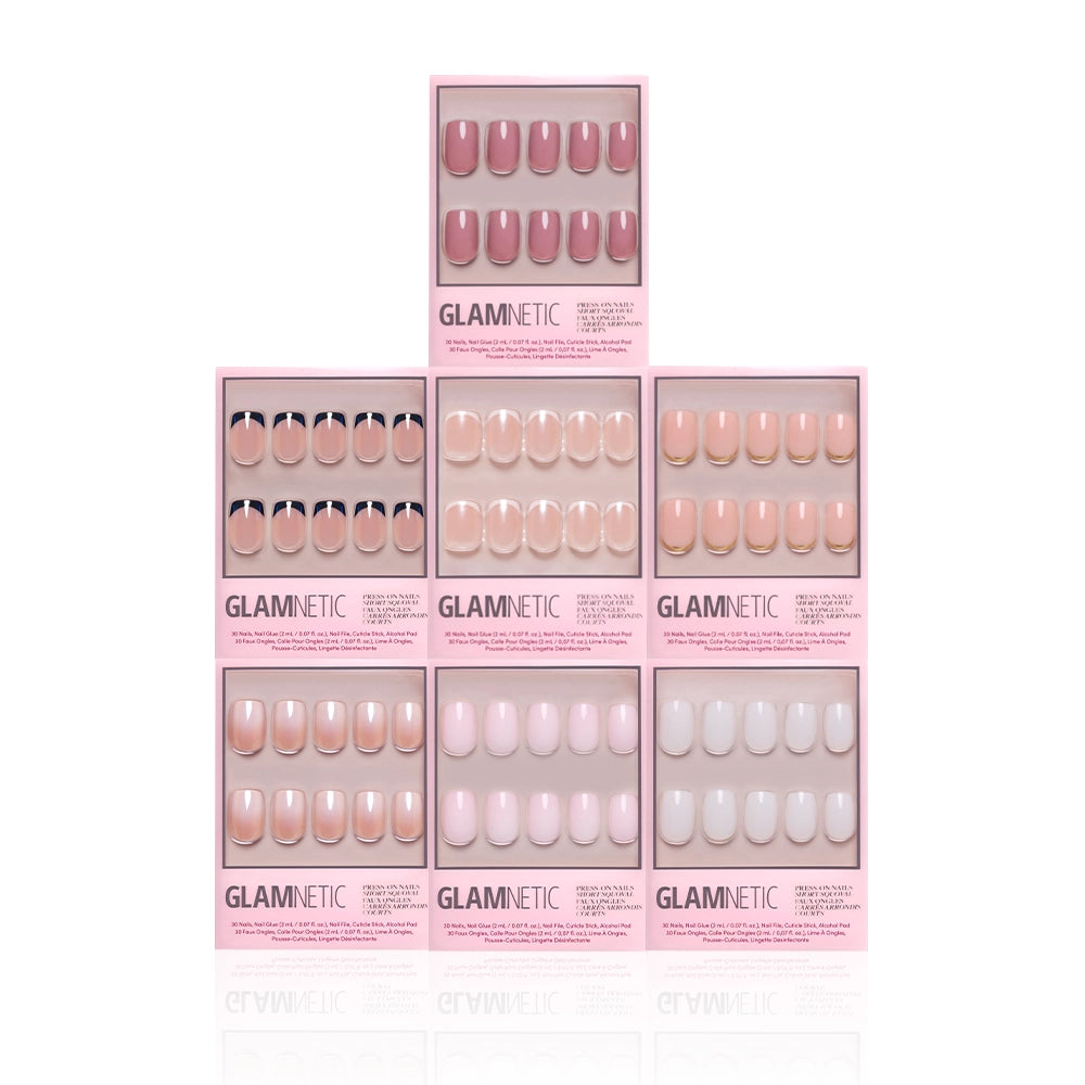 Seven boxes of Glamnetic Short Squoval Icons press-on nails are stacked in a pyramid on a white background, each box showcasing a unique pink or nude design, including milky and French tip styles. - Product image