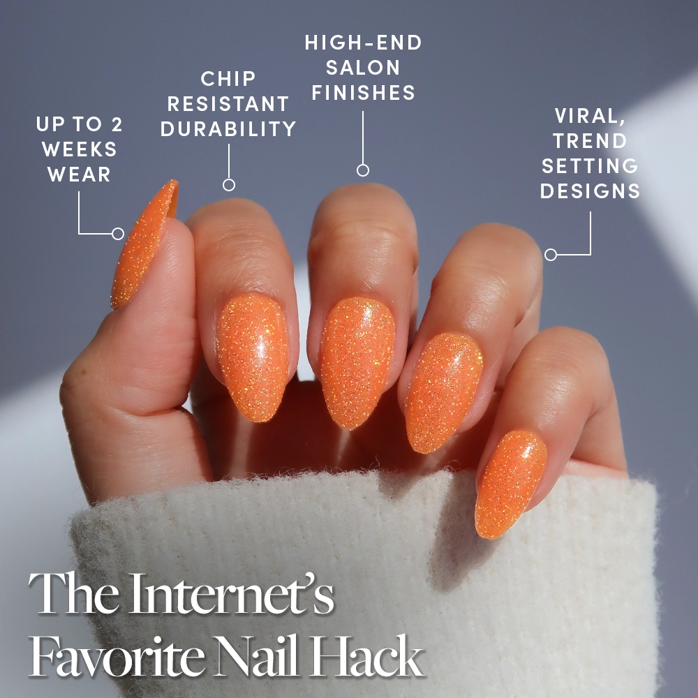 A hand with long, sparkly almond orange nails is shown, showcasing glamnetic’s Showgirl set with viral designs, chip-resistant durability, high-end salon finish, and up to 2 weeks wear. Text: The Internet's Favorite Nail Hack—meet Showgirl by glamnetic. - Product image