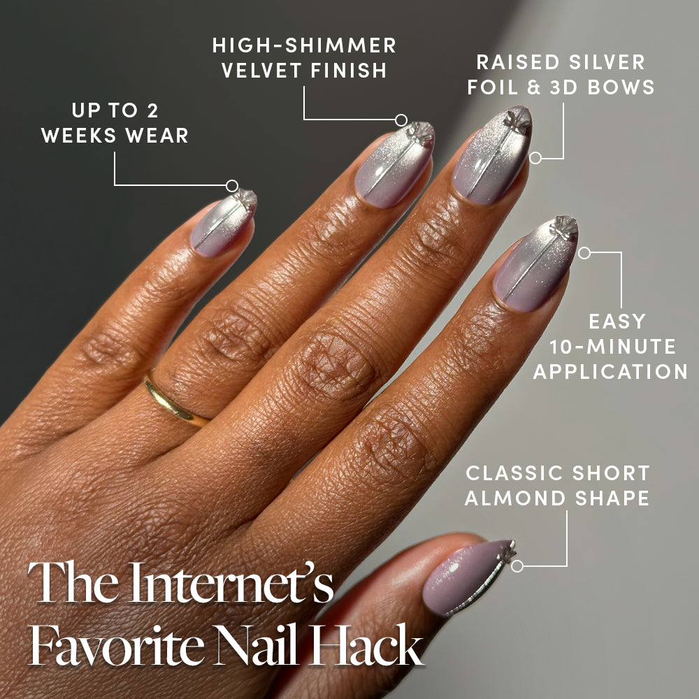A hand displays Glamnetic Silver Stockings, featuring short almond-shaped press-on nails with a shimmery grey velvet finish and 3D silver bows, alongside text overlays for two-week wear, easy application, and The Internets Favorite Nail Hack. - Product image