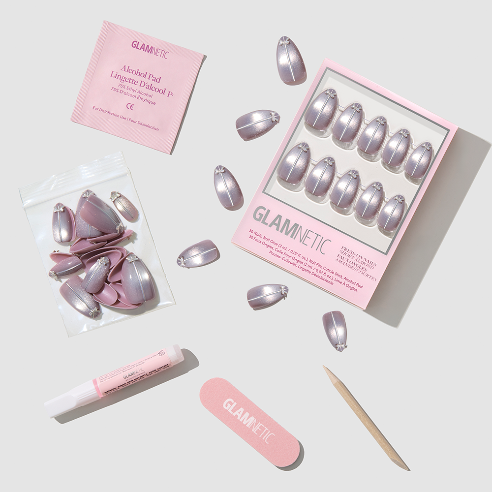Glamnetic Silver Stockings press-on nail kit featuring short almond nails in a metallic silver finish, including organized nails, extra pieces, glue, an alcohol pad, a nail file, and a wooden cuticle pusher. - Product image