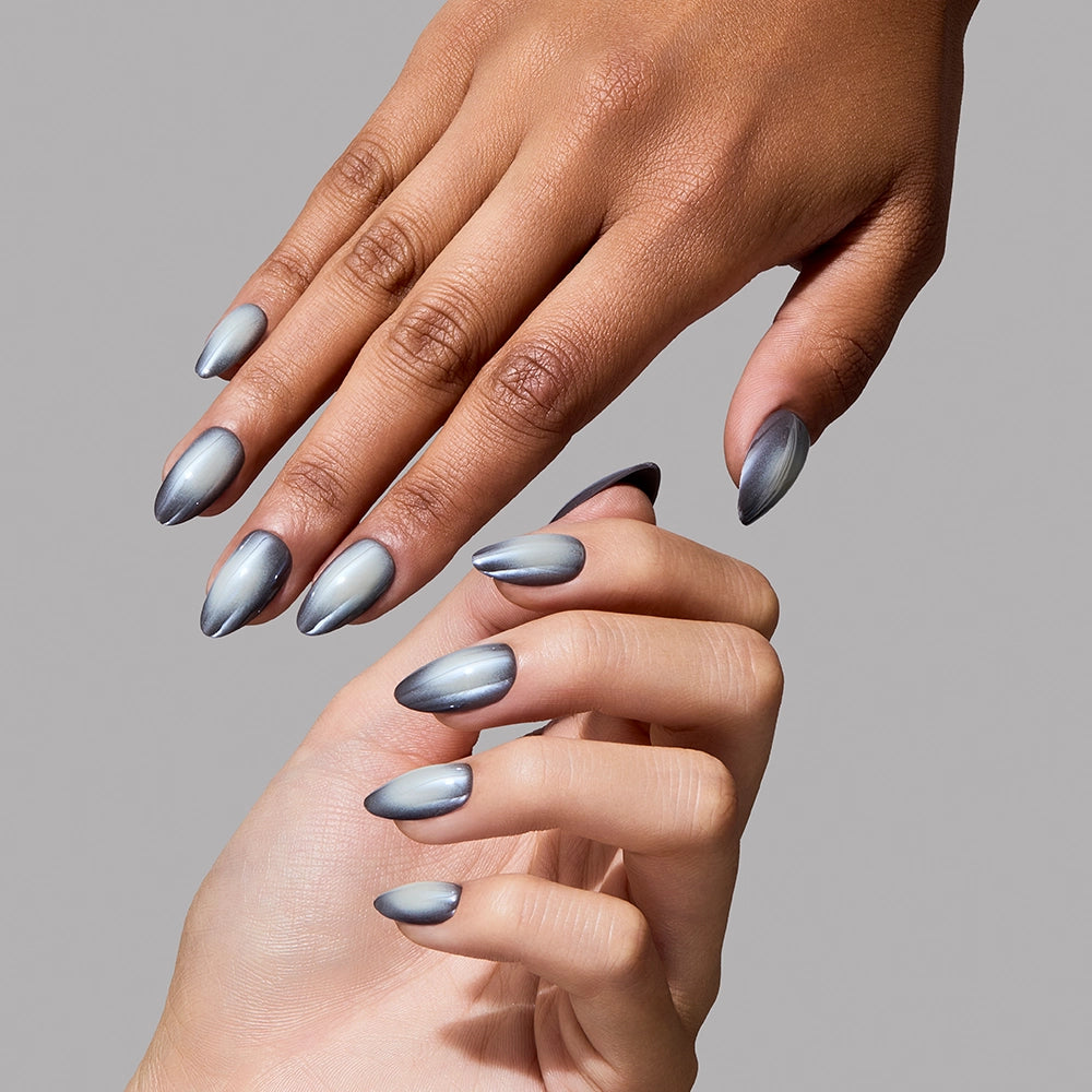 Two hands with long, almond-shaped nails painted in glamnetic’s Smoke N’ Mirrors—a shiny metallic silver polish with salon-quality durability—are posed against a plain gray background. - Product image