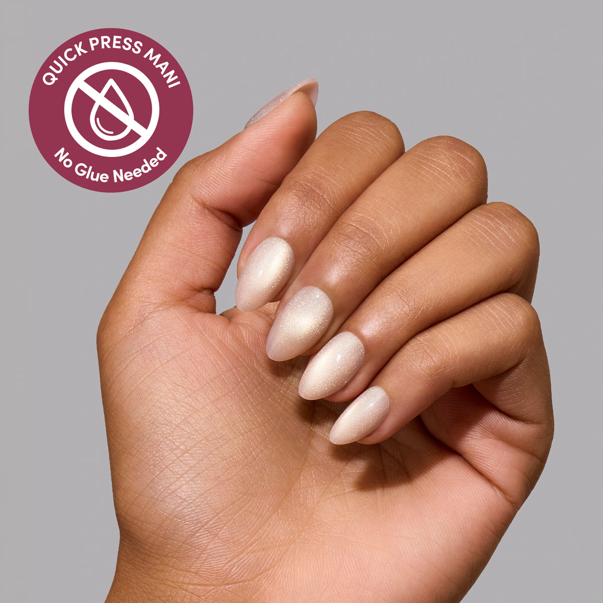 Hand with shimmery off-white Snow Haze extra short almond nails and a circular badge reading Quick press mani, no glue needed. - Product image
