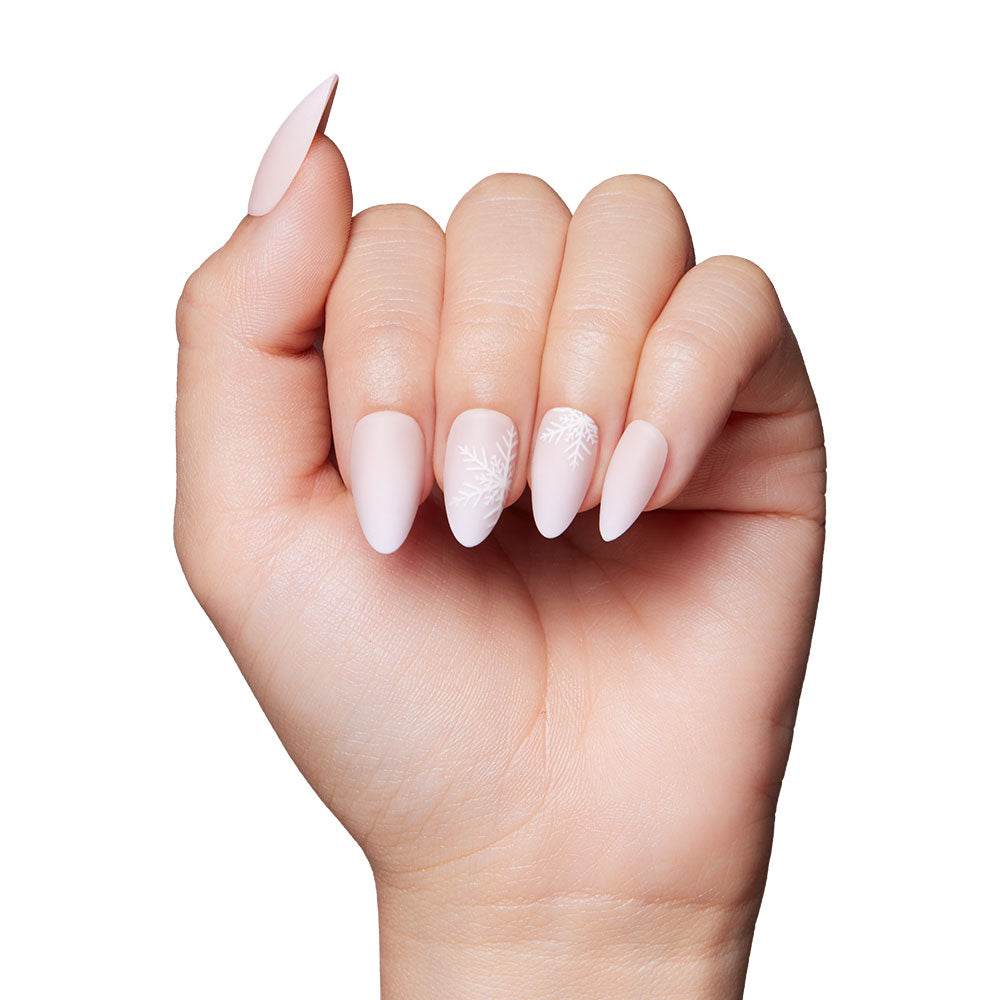 The glamnetic Snowdrift nails feature long, almond shapes in light pink with snowflake accents on the ring and middle fingers, plus a subtle matte gradient, all shown against a white background. - Product image