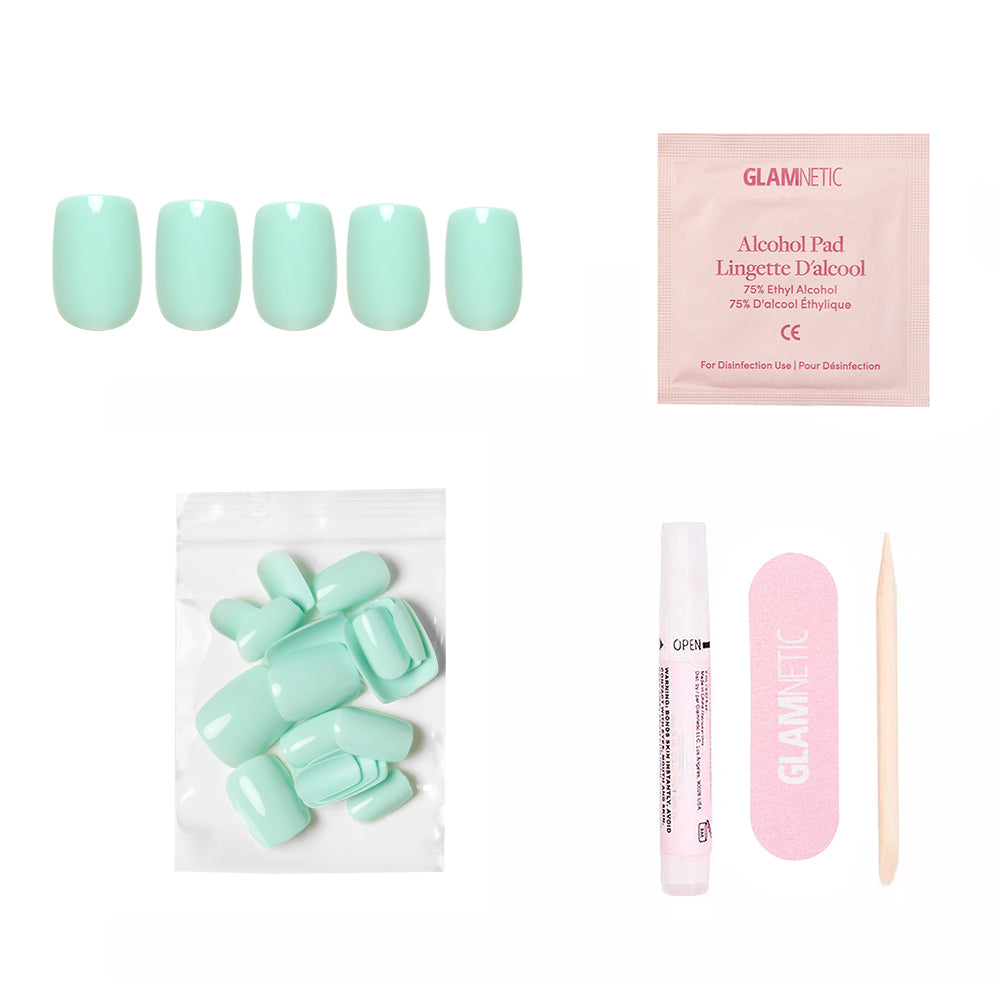 The glamnetic Soft Teal Nail Set includes short squoval press-on nails, an alcohol pad, adhesive tube, pink nail file, wooden cuticle stick, and a pouch of extra nails—all displayed on a white background. - Product image